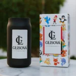 Lifestyle image of a GLISOVA candle on a wooden table with flowers