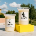 GLISOVA artisan candle displayed on a pink table in a vibrant patio setting