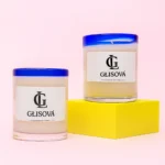 Hand-poured natural soy wax candle on a pink background.